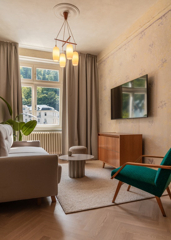 Apartmán 2KK – obývací pokoj s designovým osvětlením a výhledem do zeleně